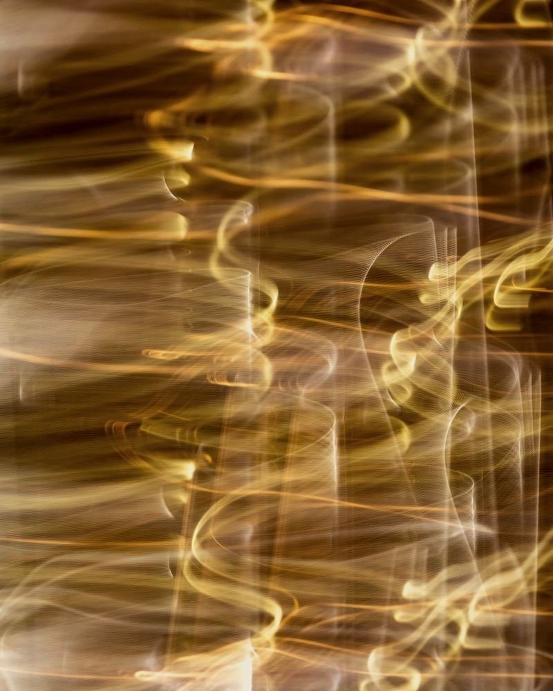 Long-exposure streaks of golden light on black
