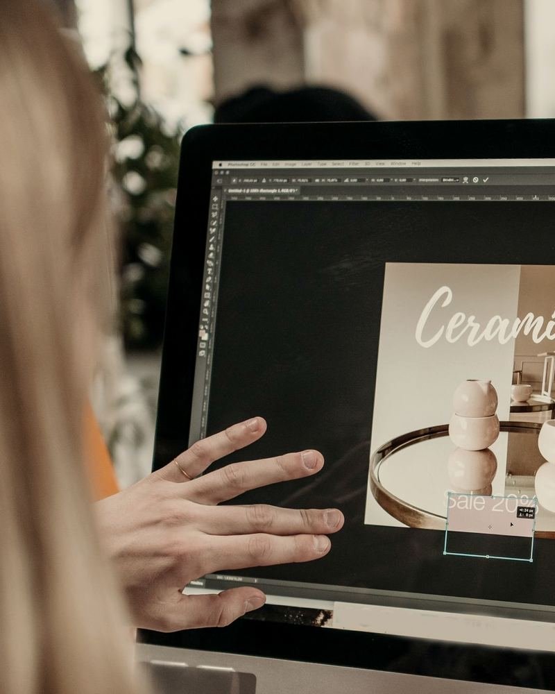 Over the shoulder of a designer laying out a product promo on her screen