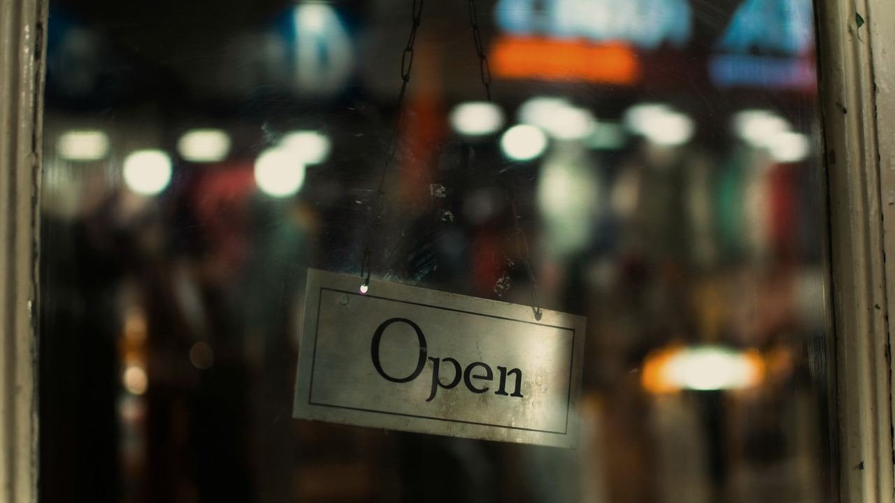 Un letrero de Open en la vitrina de una tienda al atardecer
